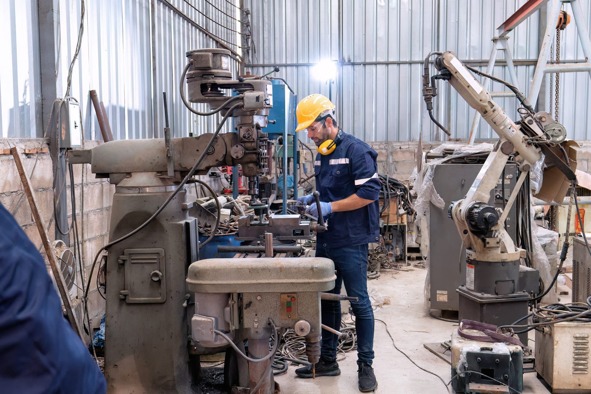 In robotic repair shop engineer use drilling machine fabricate part and vernier caliper measuring